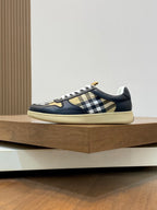 Navy low-top sneakers with check side panel, gold detail, and beige textured sole