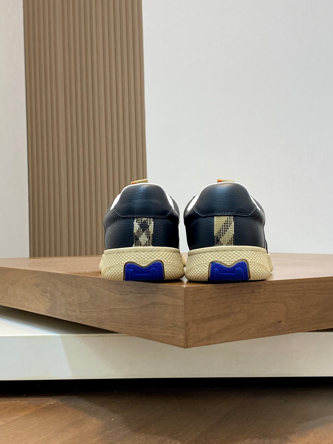 Sneakers back view with blue tread detail and textured beige soles