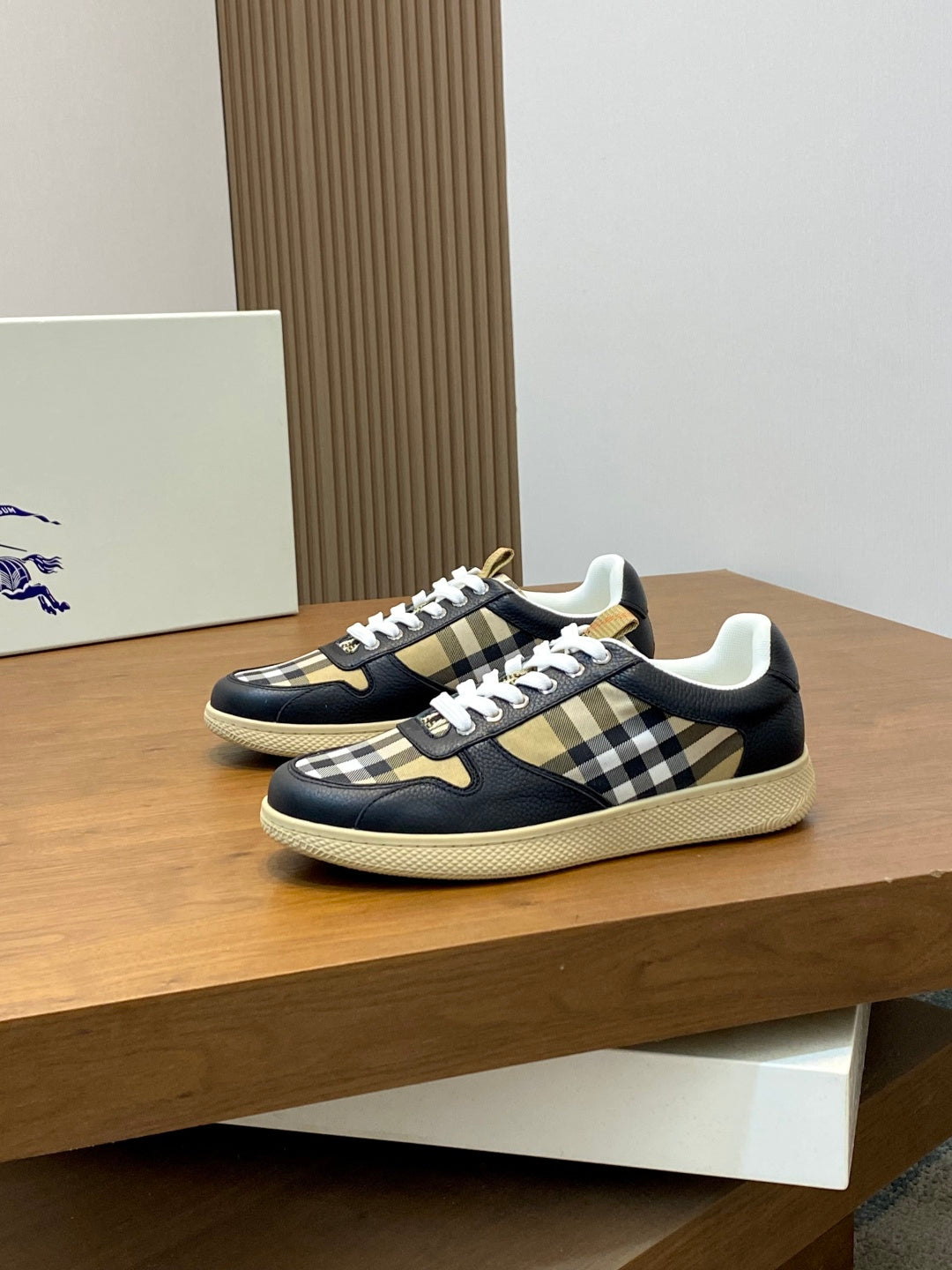 Navy low-top sneakers with white laces and black, beige check side panels