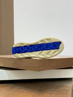 Burberry sneakers outsole with blue logo text on beige rubber tread