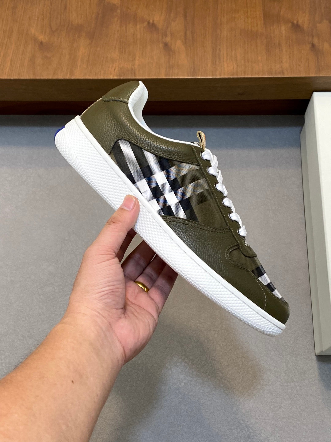 Burberry luxury sneaker close-up, olive green leather with check stripe