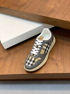 Burberry low-top sneakers on steps, dark gray uppers with check accents and white laces