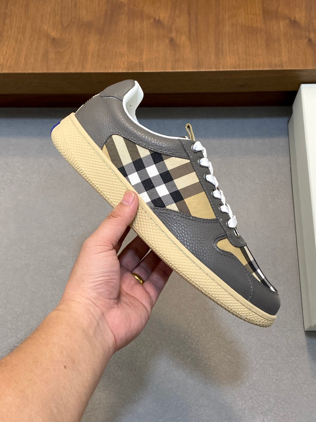 Burberry low-top sneaker side view with check panel, white laces, and beige textured sole