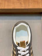 Burberry sneaker opening with white interior lining, dark gray upper, and check detail