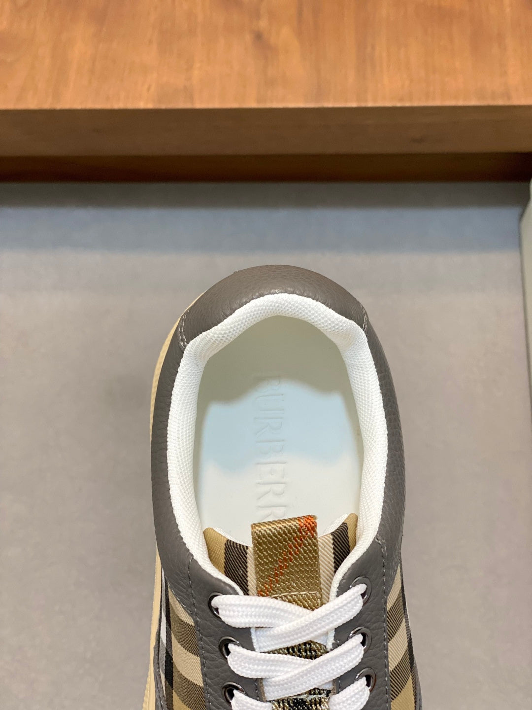 Burberry sneaker interior view, white lining with fabric label at heel