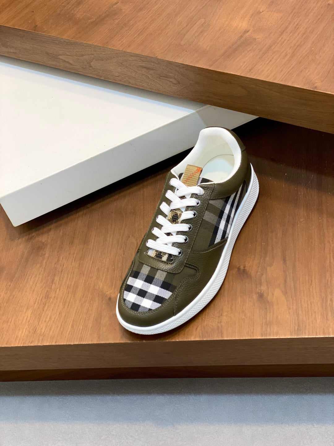 Olive low-top sneaker with white laces and black-and-white check stripe detail