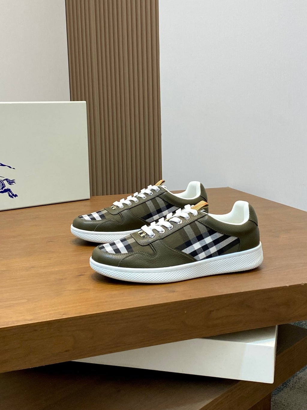 Olive low-top sneakers with white laces and black-and-white check stripe detailing