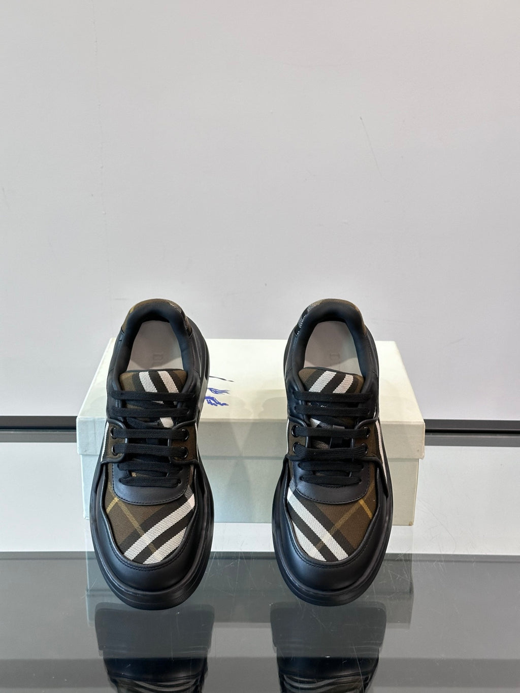 Back view of dark navy lace-up sneakers with beige plaid interior panel