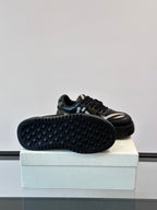 Shoe outsole view: dark navy sneakers with hex tread sole and plaid side stripe