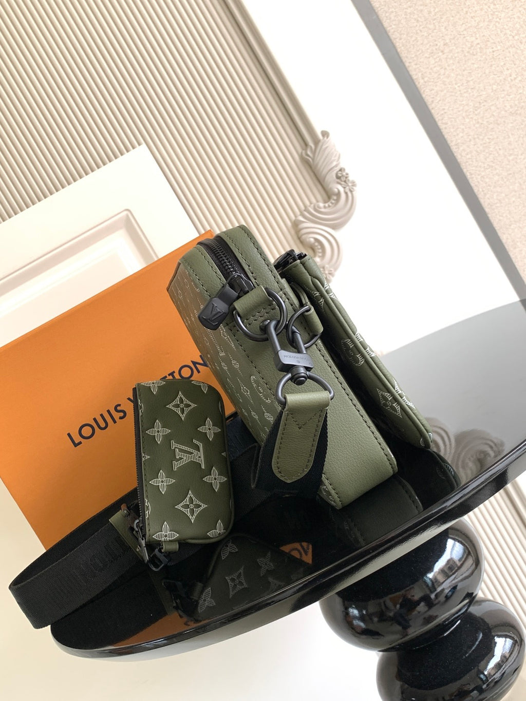Olive green crossbody bag with adjustable strap, front pocket and metal buckle detail