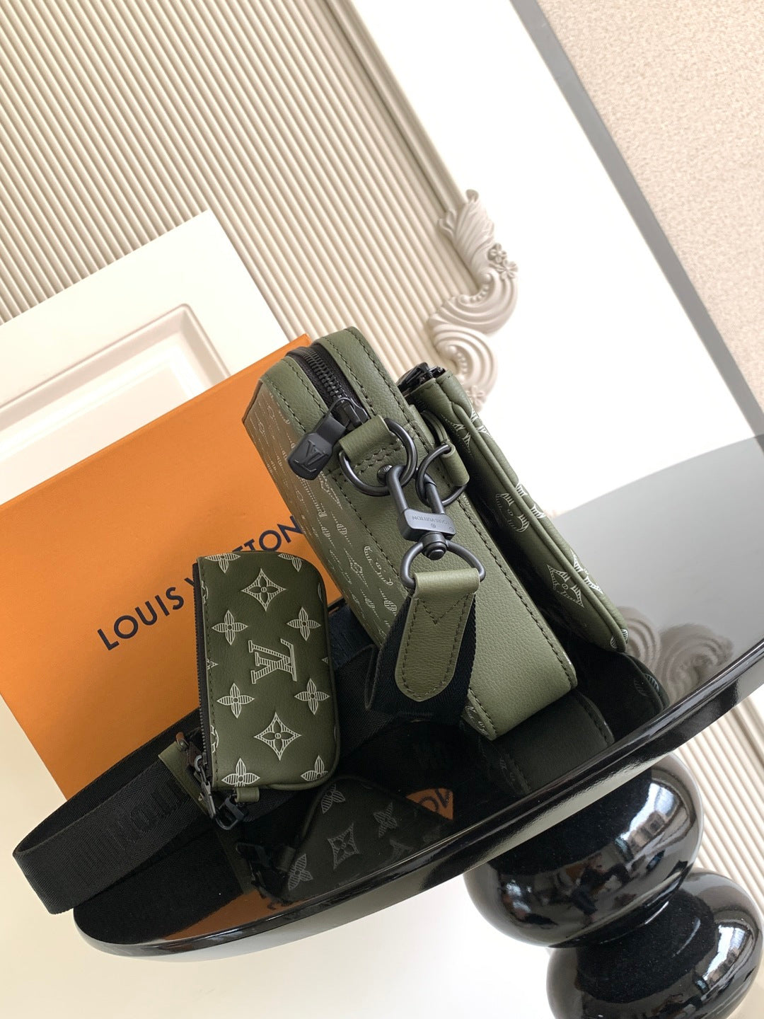 Olive green crossbody bag with adjustable strap, front pocket and metal buckle detail