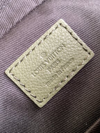 Light green leather label on bag with embossed Louis Vuitton Paris text