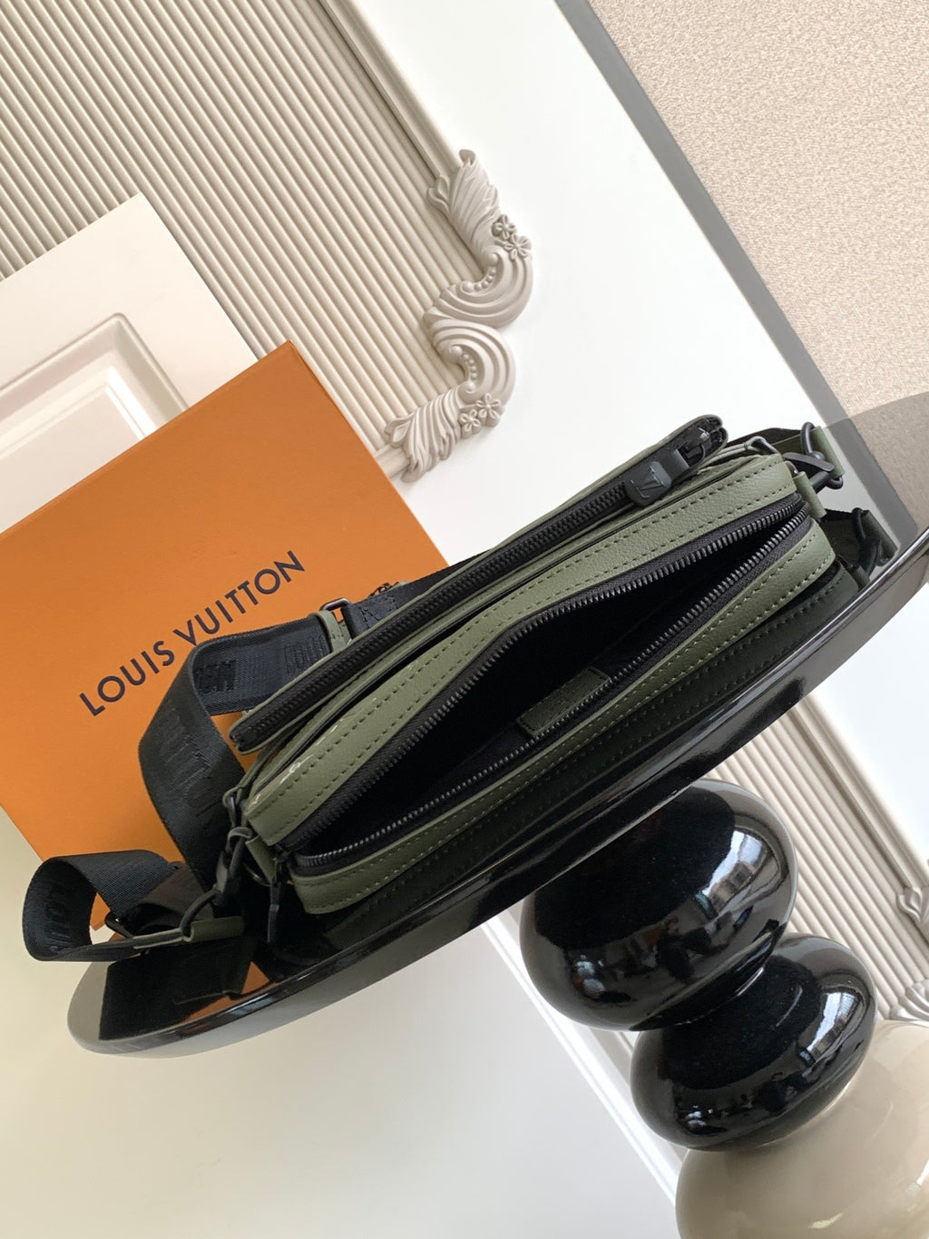 Olive green zip crossbody bag with monogram panels, front pockets and double zipper
