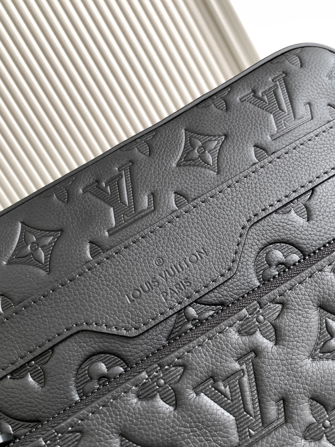 Textured leather with debossed monogram pattern and contrast stitching, dark.