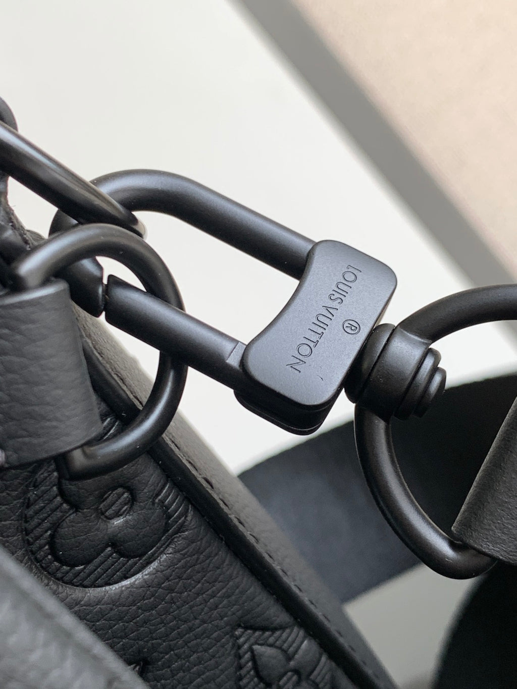 Leather strap with metal D-ring and clasp, dark tone hardware.