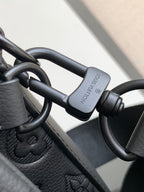 Leather strap with metal D-ring and clasp, dark tone hardware.