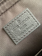 Leather interior label with embossed Louis Vuitton Paris text, stitched dark.