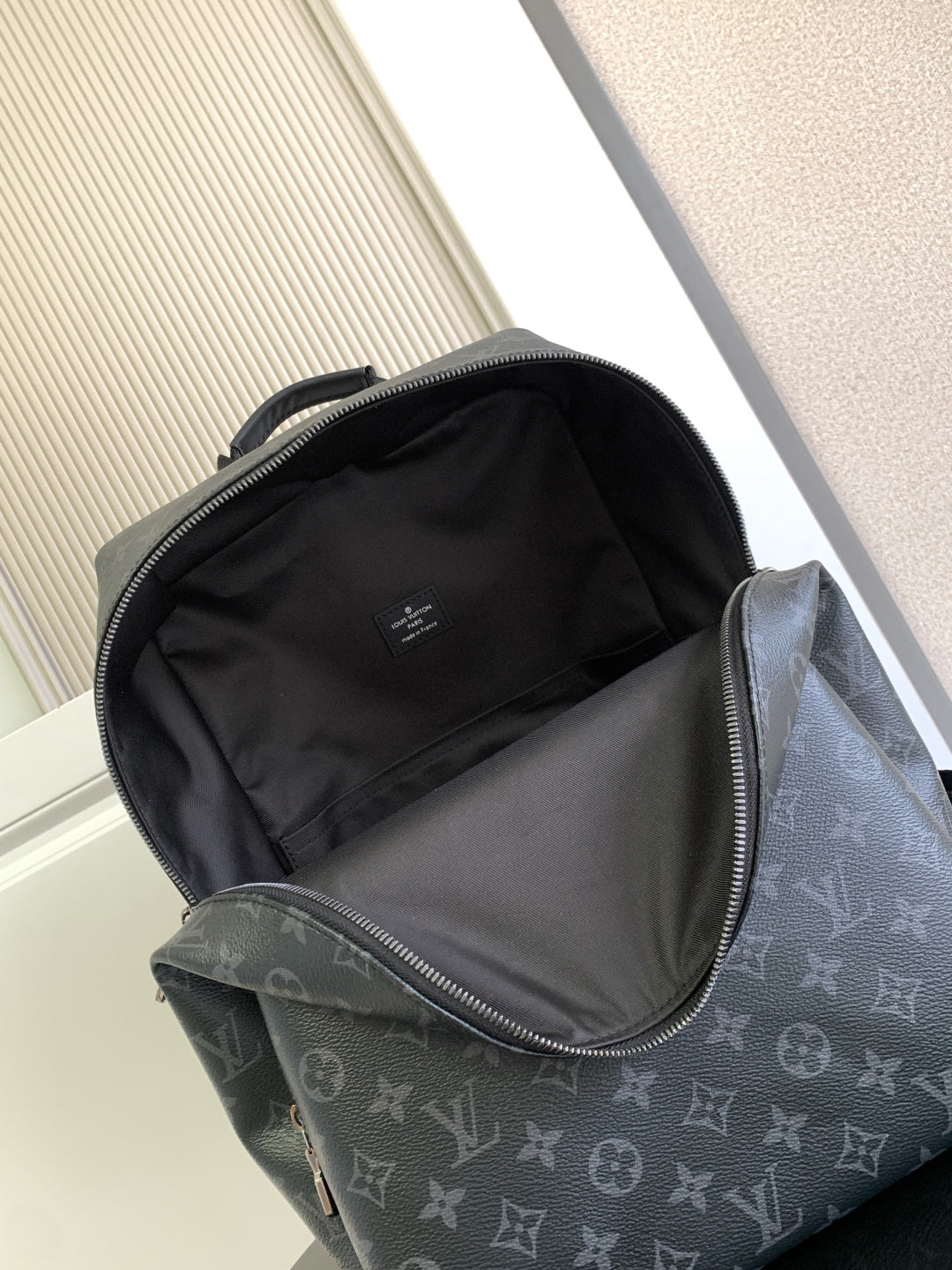 Louis Vuitton monogram backpack open top showing black fabric interior