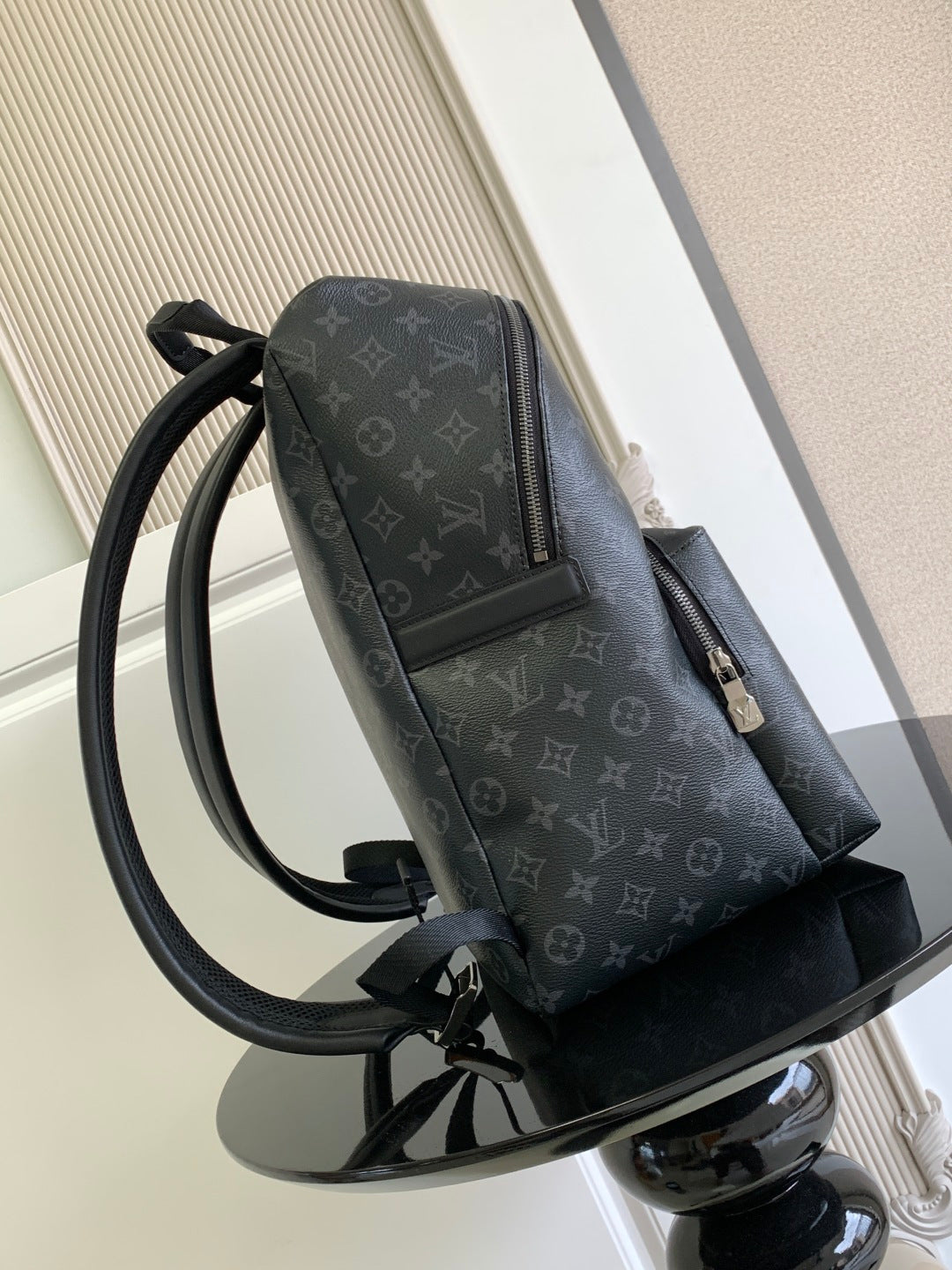 Louis Vuitton monogram backpack side view with zip pocket and adjustable strap