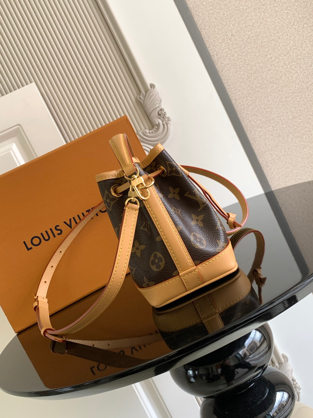 Louis Vuitton monogram bucket bag with tan leather straps and gold-tone hardware