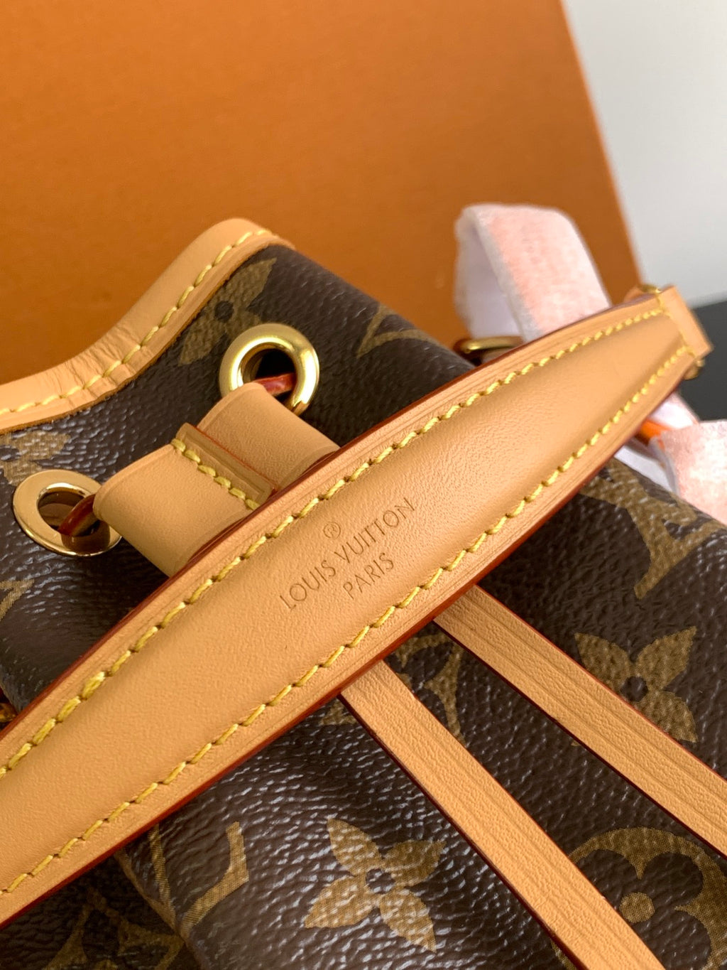 Louis Vuitton monogram bag with tan strap, gold ring hardware, and stitching