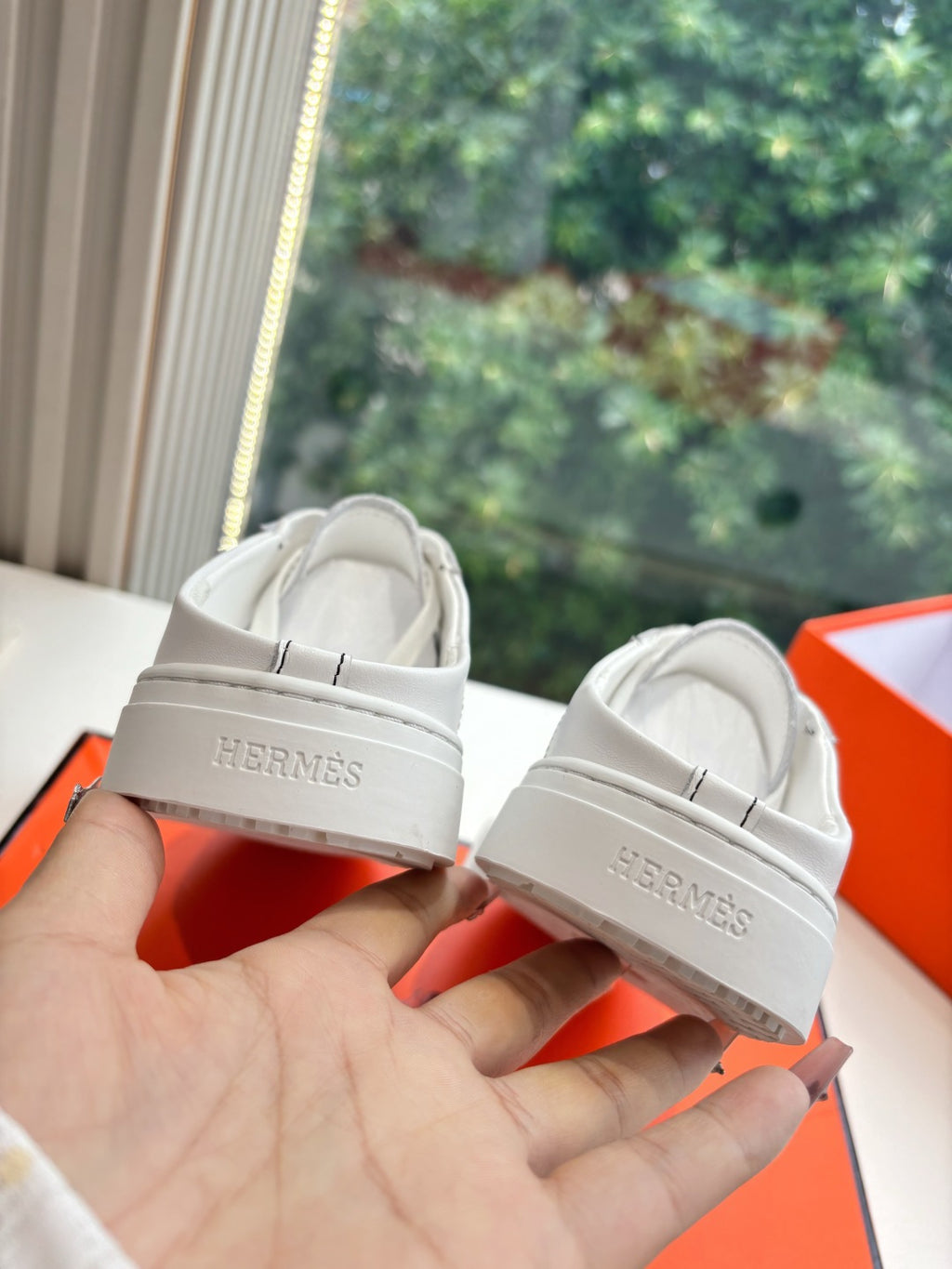 White leather sneakers with HERMÈS logo on heel tab and lace-up front
