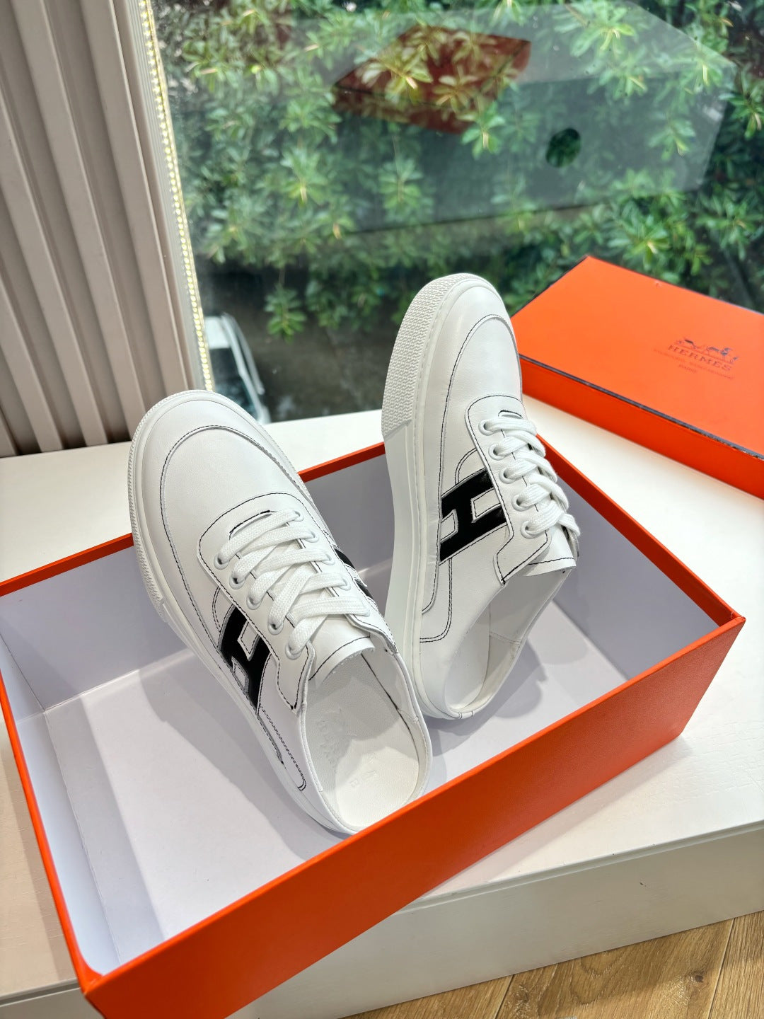 White leather sneakers, black H side logo, lace-up design and rubber sole