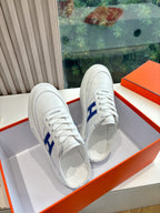 Pair of white low-top sneakers with blue H side logo and lace-up design
