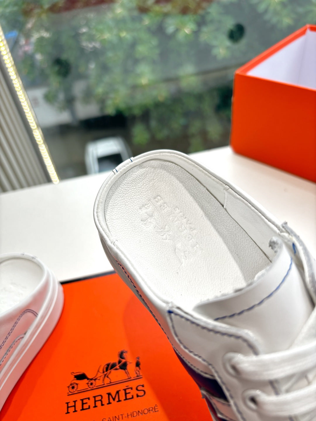 White sneaker interior view with gray lining and stitched trim edges