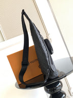Louis Vuitton bag side view with long strap and zipper pocket in dark embossed leather