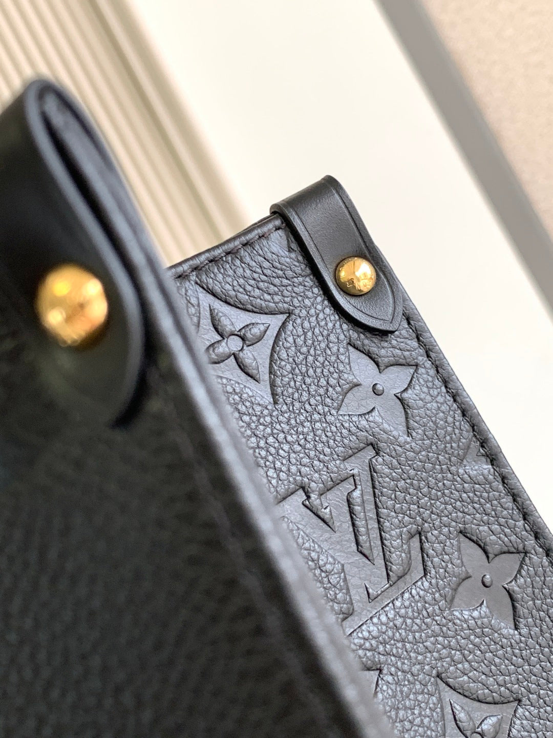 Louis Vuitton monogram tote bag side panel with snap button detail