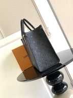 Louis Vuitton embossed tote bag with dark monochrome finish and top handles