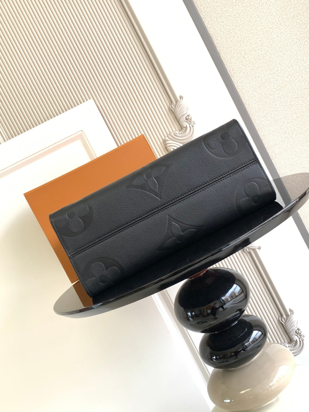 Louis Vuitton monogram tote bag with zip closure and dark embossed front