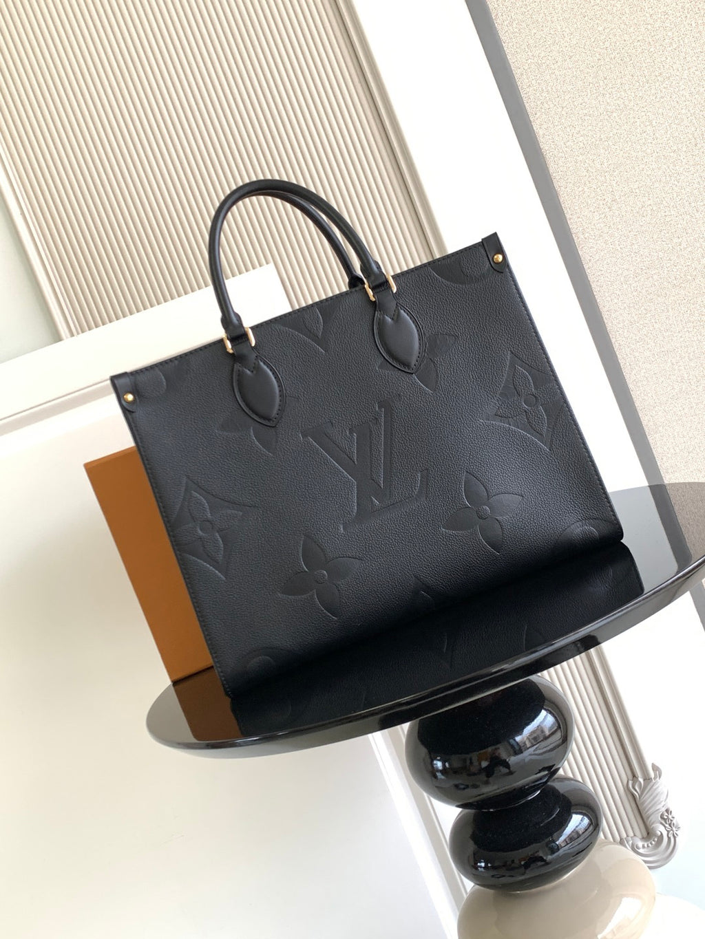 Louis Vuitton embossed tote bag with structured shape and top handles