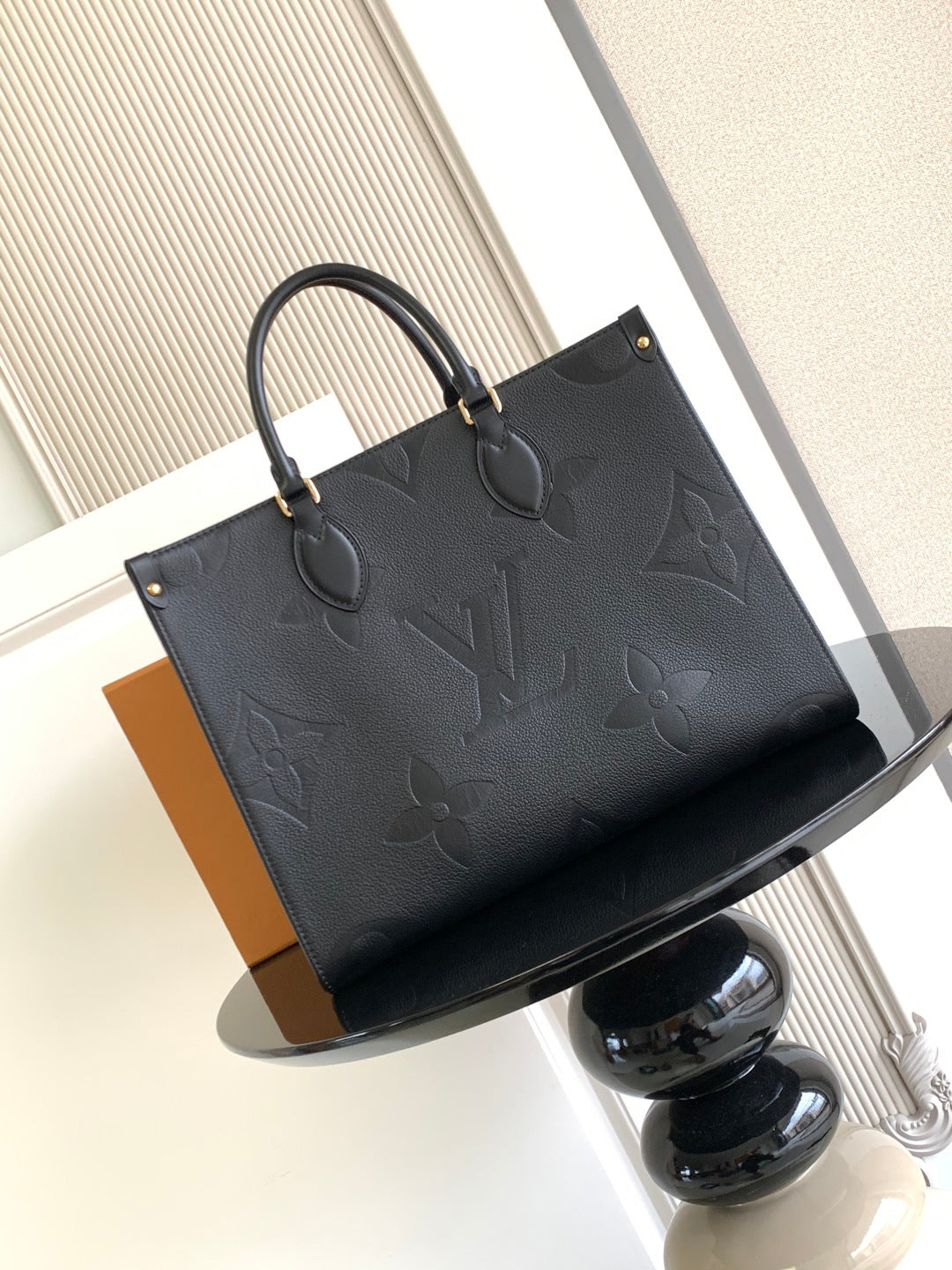 Louis Vuitton embossed tote bag with top handles and dark leather trim