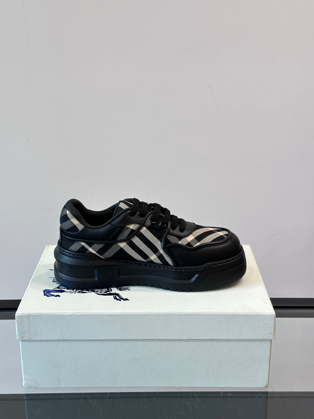 Black lace-up sneakers with plaid side panels and cushioned collar, 3/4 view