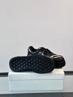 Black sneakers with honeycomb-textured outsole and plaid side panel, side view