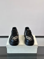 Black lace-up sneakers with plaid side stripe pattern and chunky low profile sole