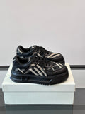 Black low-top sneakers with plaid panels, lace-up front, and thick rubber sole