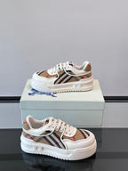 White leather low-top sneakers on box, front-left angle with Burberry check trim