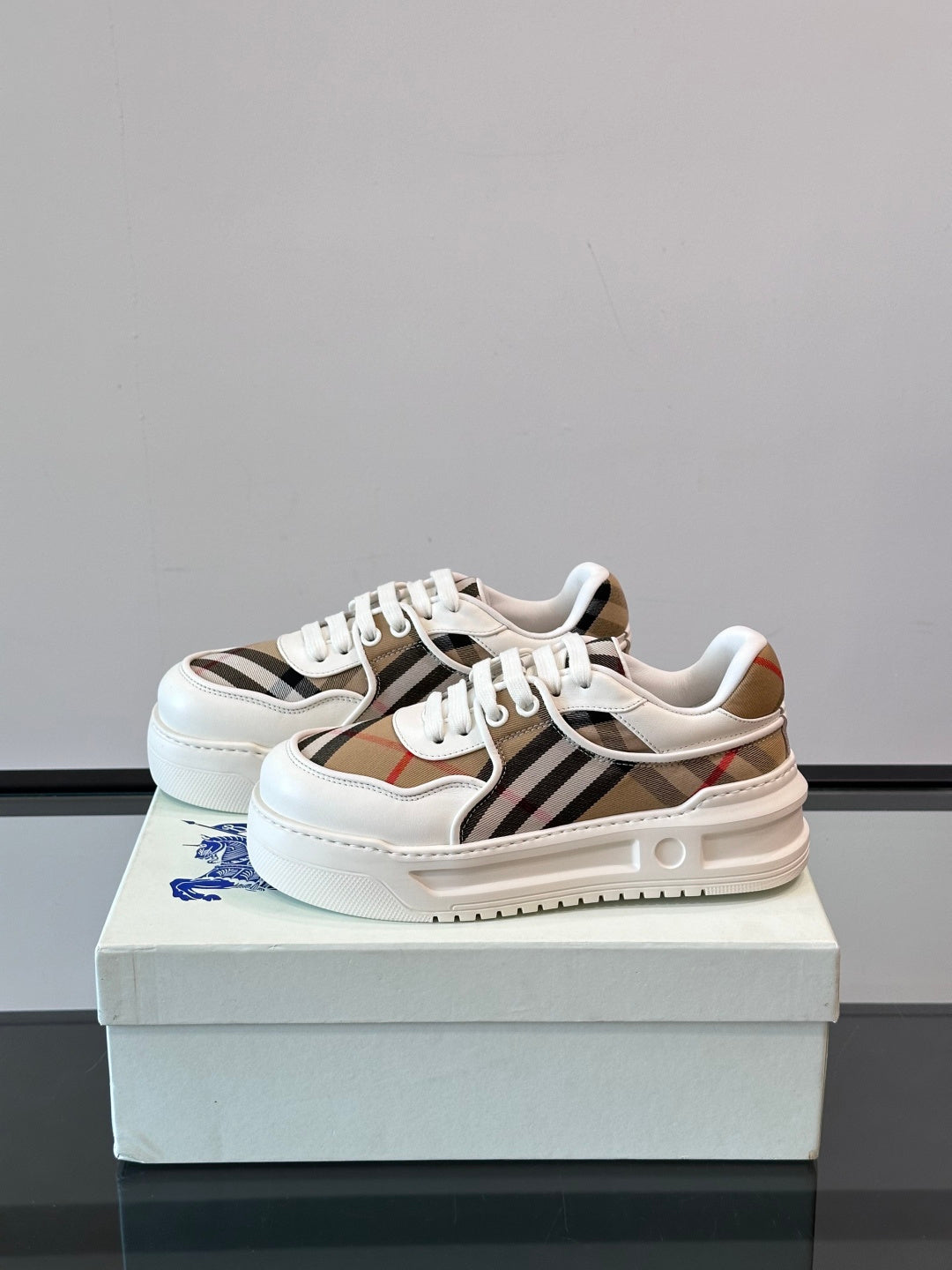 White leather low-top sneakers, heel and side view with Burberry check stripe
