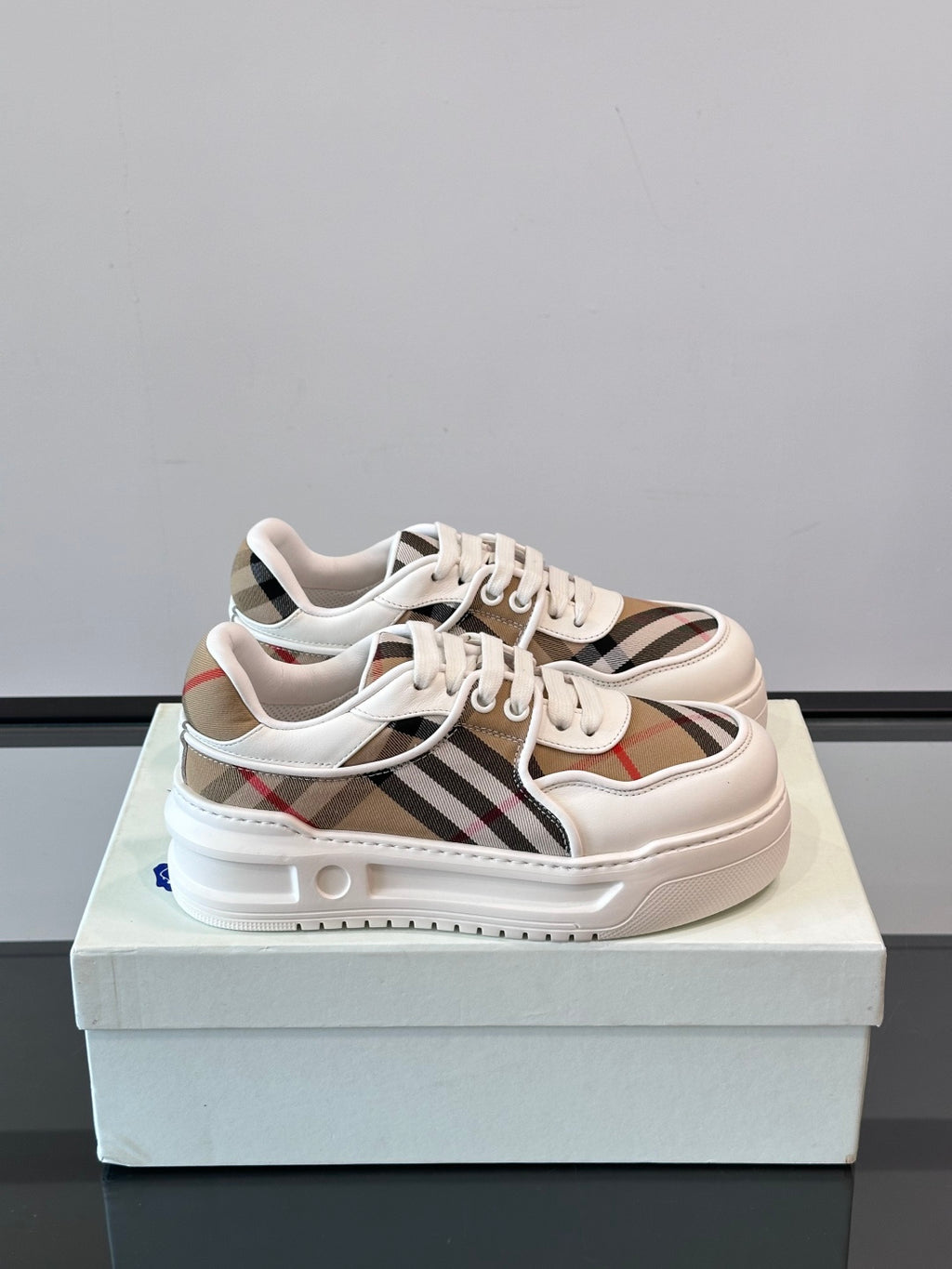 White leather low-top sneakers with Burberry check stripe and lace-up front