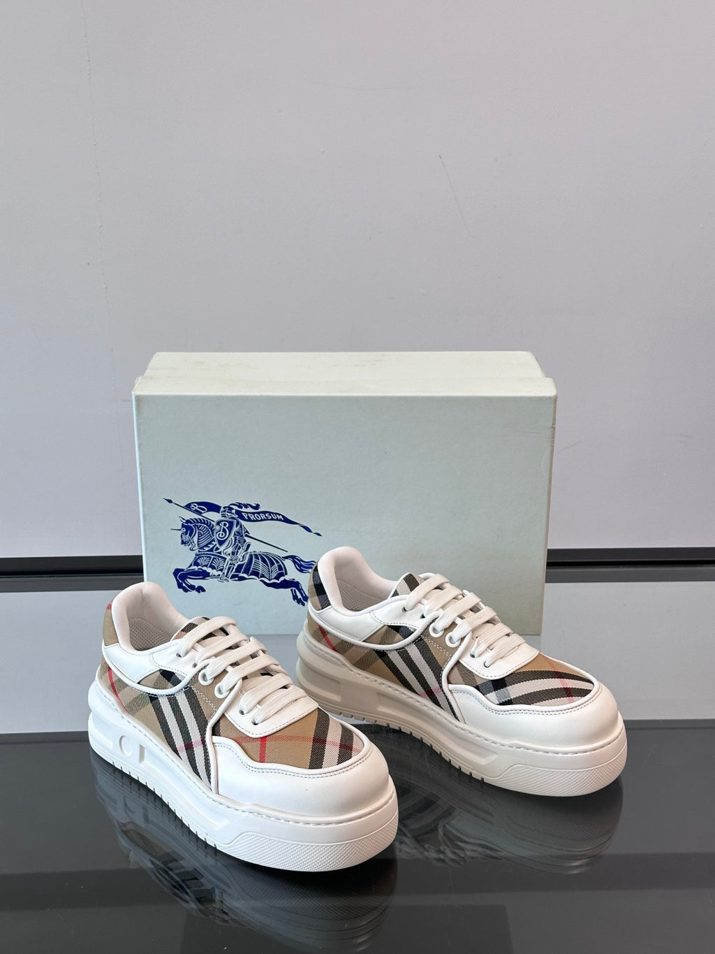 Two white leather sneakers, side-by-side view with Burberry check inserts