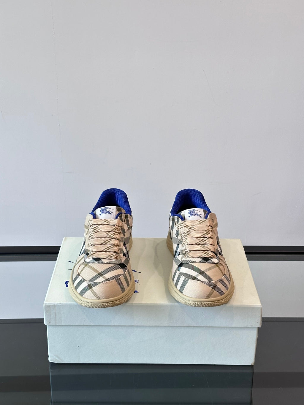 Burberry low-top sneakers, front view, beige plaid upper with blue lining and laces