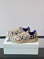Burberry plaid lace-up sneakers, side view on box; blue trim and tan sole