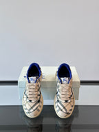 Burberry sneakers, straight-on view; beige plaid uppers with blue laces and collar