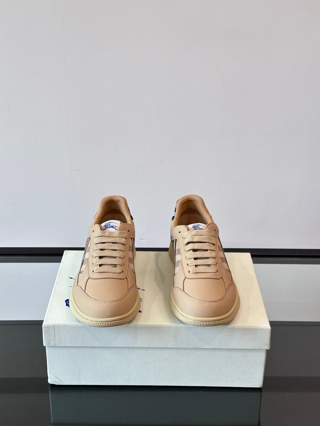 Sneakers pair with Burberry check accents, beige leather lace-up design