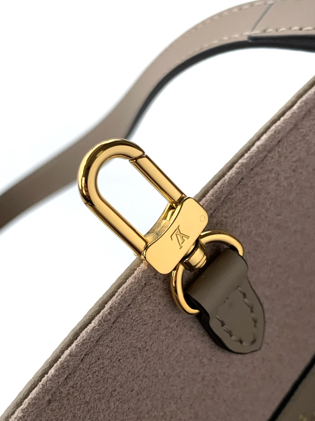 Louis Vuitton strap detail with gold padlock hardware on taupe leather