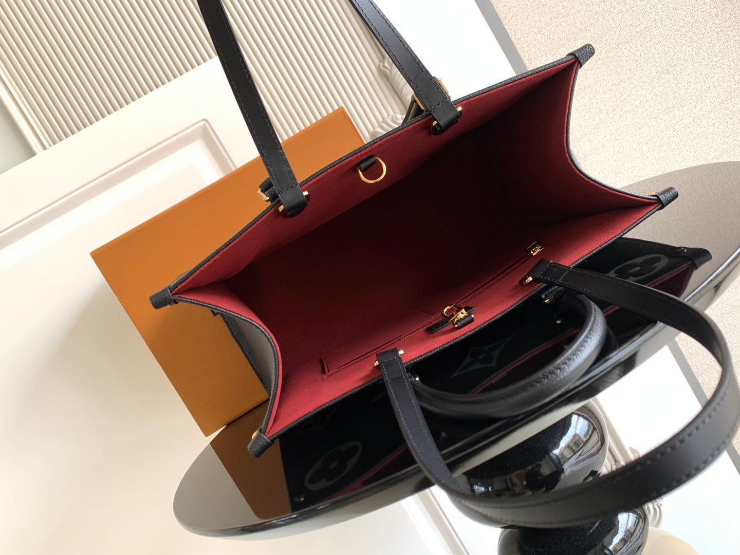 Louis Vuitton handbag open view with red interior lining and top clasp frame
