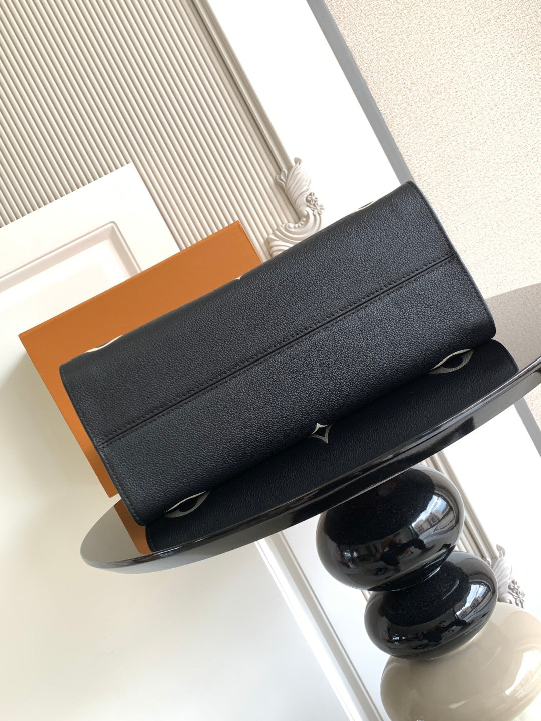 Louis Vuitton bag in dark pebbled leather with wide flap and side strap closures